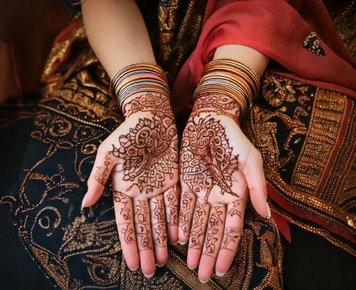 A close-up of intricate Moroccan henna designs on a woman's hand, showcasing the traditional art form that has been passed down through generations, with delicate patterns symbolizing beauty, fertility, and cultural heritage.