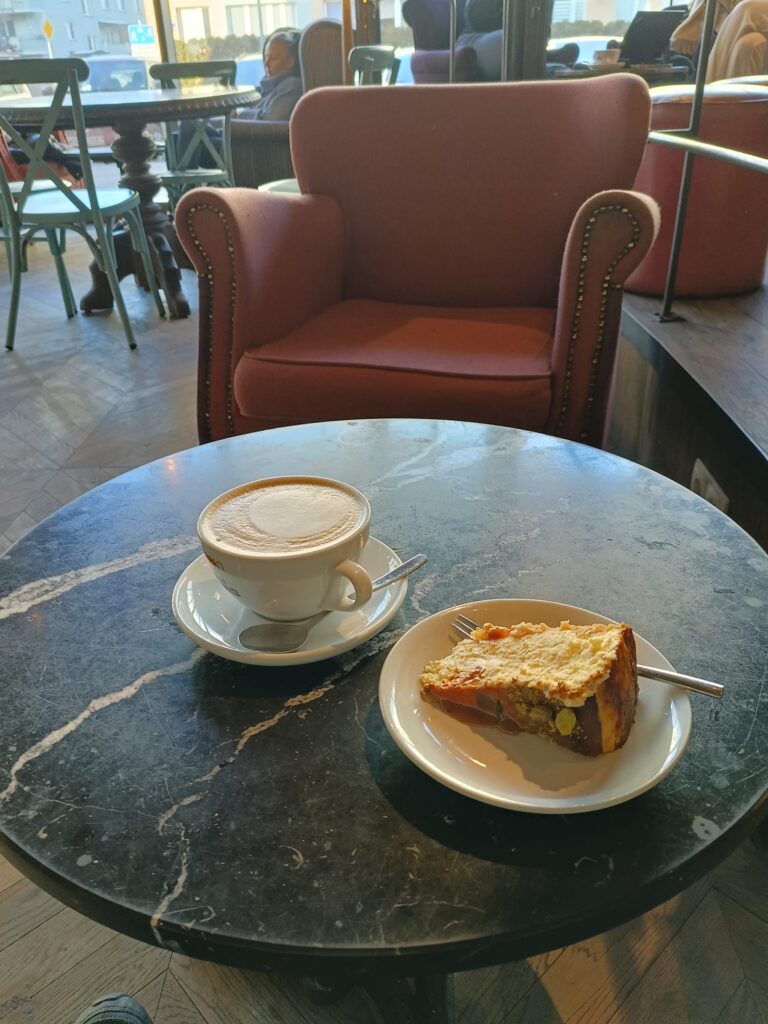 A steaming cup of coffee on a wooden table with sunlight streaming through a window, creating a warm and inviting morning atmosphere.