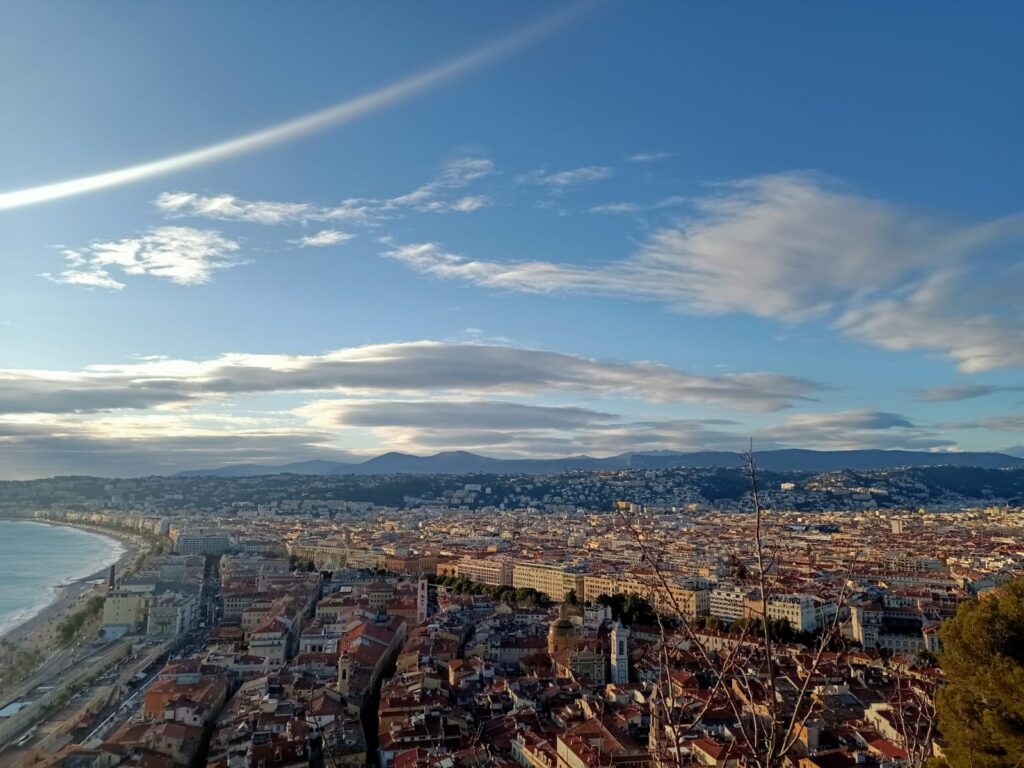 A panoramic view of Nice, France, showcasing its vibrant Old Town, turquoise Mediterranean waters, and the iconic Promenade des Anglais.