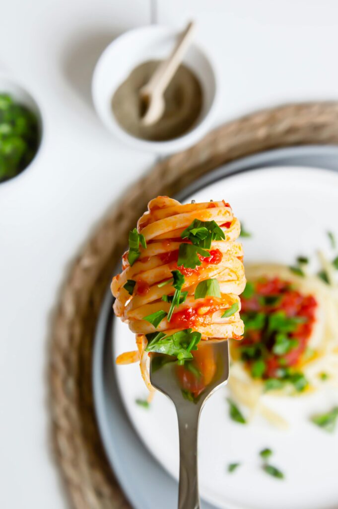 A traditional Spanish plate filled with delicious spaghetti, garnished with fresh herbs and a rich tomato sauce.