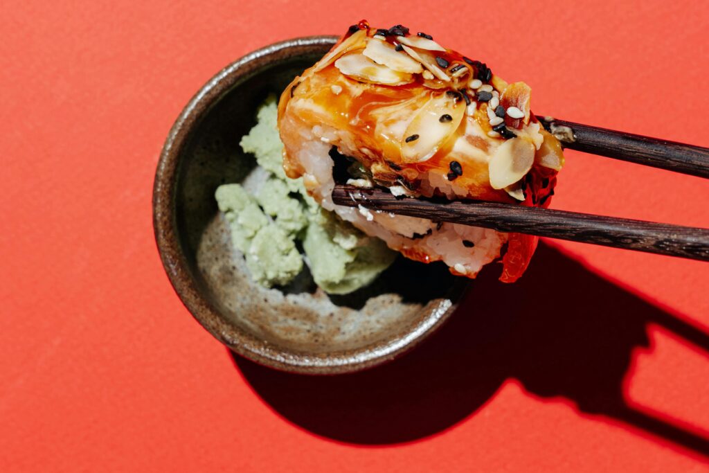 A beautifully arranged platter of fresh sushi, featuring nigiri with slices of salmon, tuna, and yellowtail, alongside colorful maki rolls, served with soy sauce, wasabi, and pickled ginger on a traditional Japanese plate.