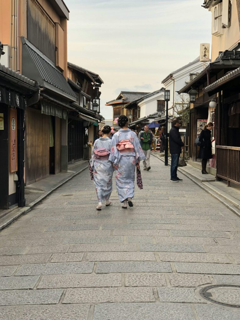 A serene view of Kyoto, Japan, showcasing traditional wooden houses, vibrant cherry blossoms, and historic temples, capturing the timeless beauty of Japan’s cultural heart.